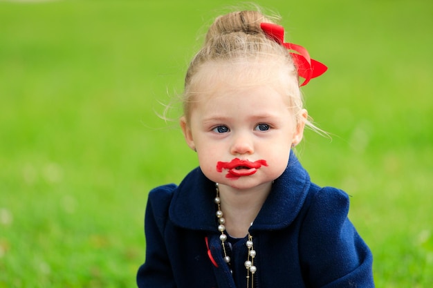 Bambina con il viso macchiato di rossetto