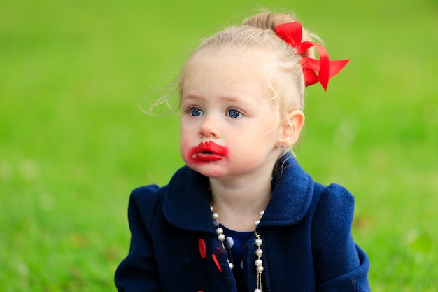 Bambina con il viso macchiato di rossetto