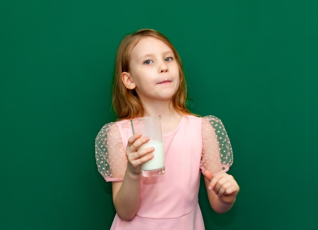 Bambina con in mano un bicchiere di latte