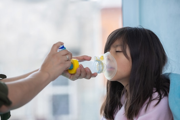 Bambina con inalatore per l'asma
