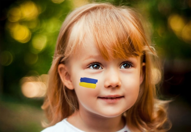 Bambina con la bandiera dell'ucraina sulla guancia