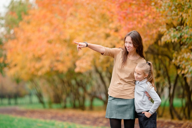 Bambina con la mamma all&#39;aperto nel parco al giorno di autunno