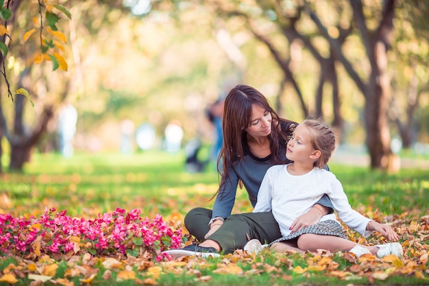 Bambina con la mamma all'aperto nel parco al giorno di autunno