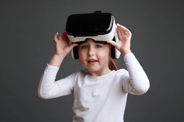 Bambina con le cuffie da realtà virtuale. Tecnologia innovativa e concetto di istruzione.