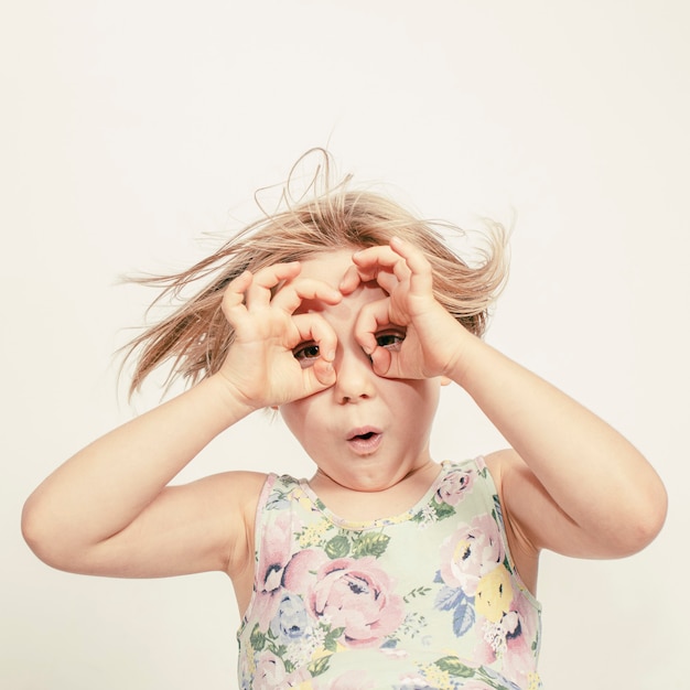 Bambina con le mani sugli occhi per simulare gli occhiali