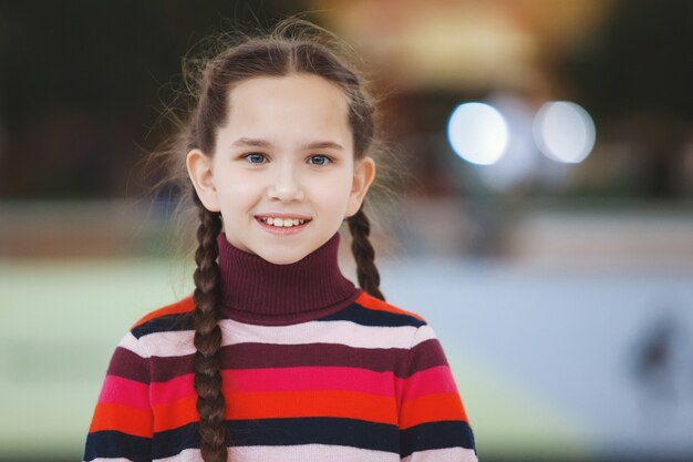 Bambina con le trecce nel centro commerciale che fa una faccia buffa