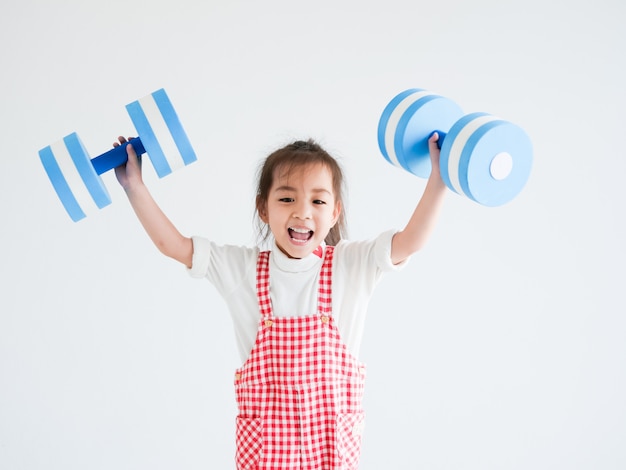 bambina con manubri blu su sfondo bianco