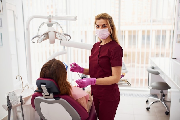 Bambina con occhiali protettivi in visita al dentista in clinica Concezione della stomatologia