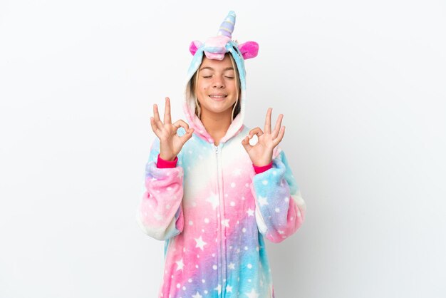 Bambina con pigiama unicorno isolato su sfondo bianco in posa zen