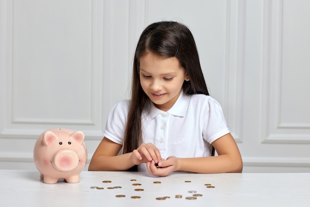 Bambina con salvadanaio a casa