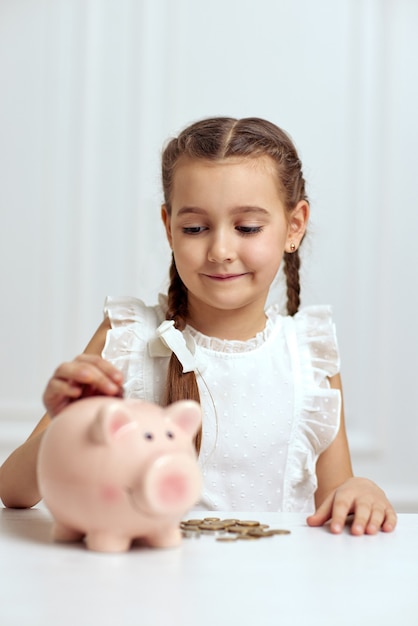 Bambina con salvadanaio a casa