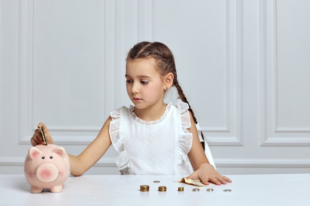 Bambina con salvadanaio a casa