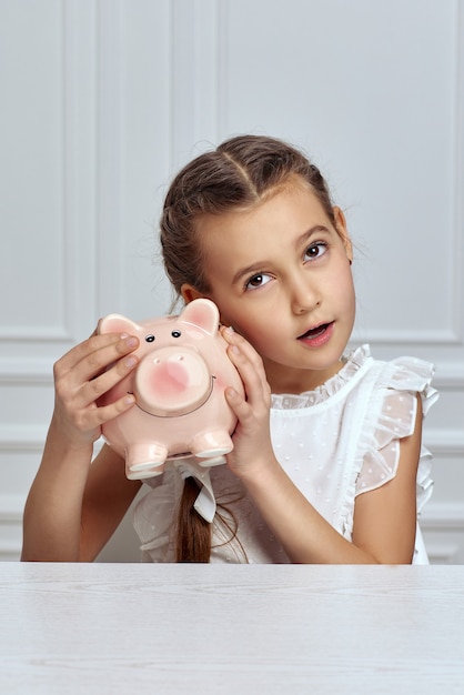 Bambina con salvadanaio a casa