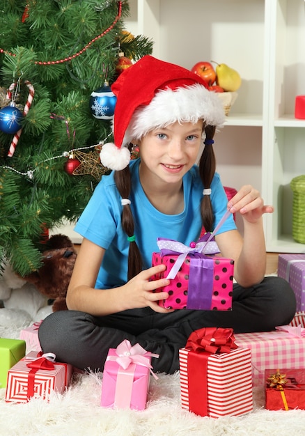 Bambina con scatola regalo vicino all'albero di Natale