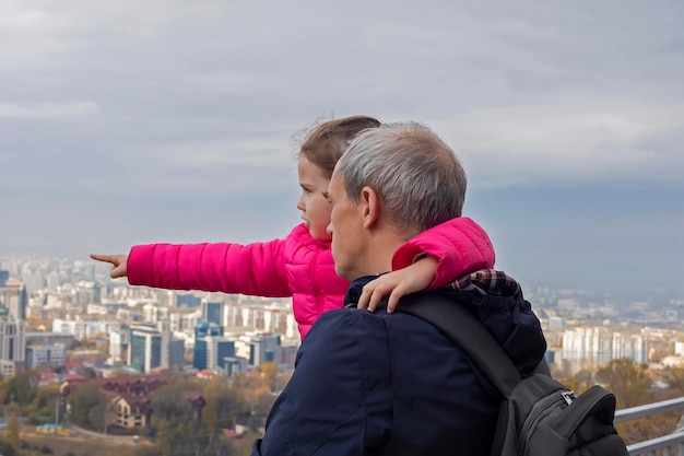 Bambina con suo padre che guarda le vedute della città di Almaty in Kazakistan