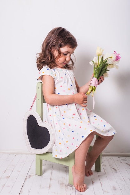 Bambina con tulipani e scatola con regalo per la mamma