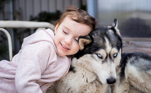 Bambina con un cane husky