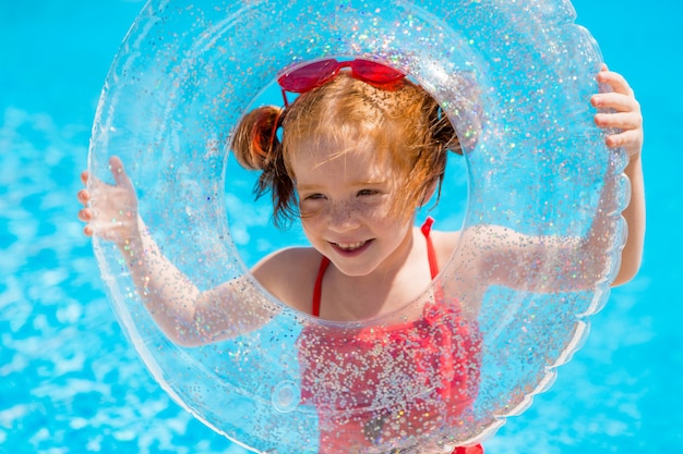 bambina con un cerchio di nuoto in piscina