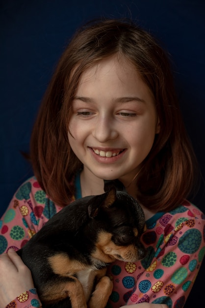 Bambina con un chihuahua. Chihuahua della holding della ragazza. Ragazza con il suo animale domestico tra le braccia.