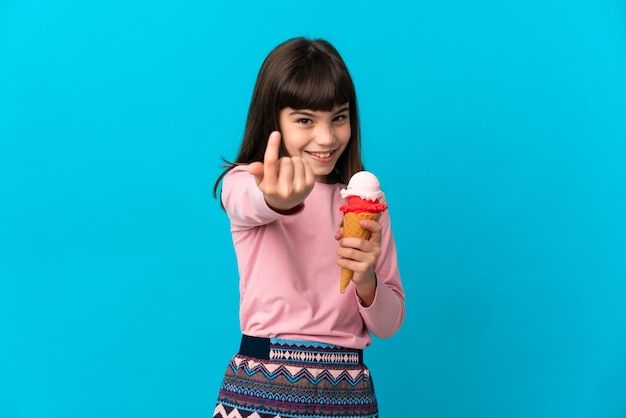 Bambina con un gelato alla cornetta isolato su sfondo blu che fa un gesto imminente