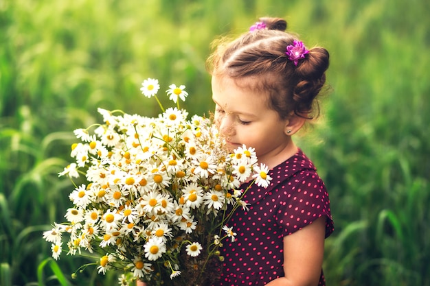 bambina con un grande mazzo di fiori margherite