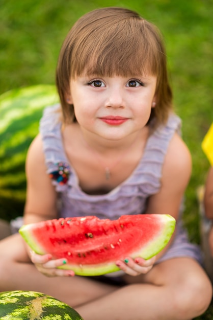 Bambina con un pezzo di anguria in mano