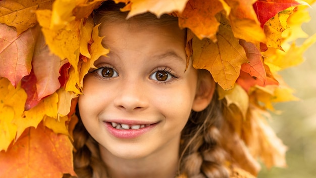 bambina con una corona di foglie di acero in testa.