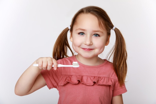 Bambina contenta sorridente mentre si lava i denti