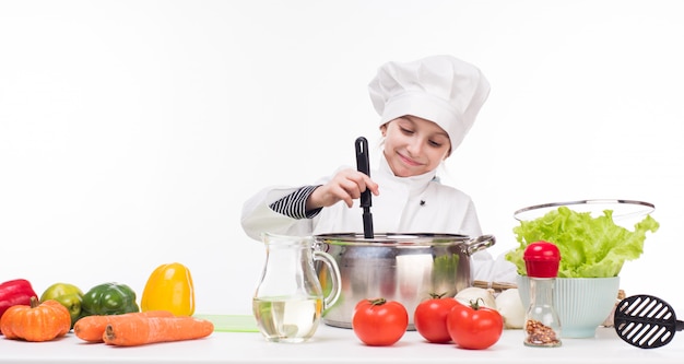 Bambina-cucinare mescolando il piatto in padella