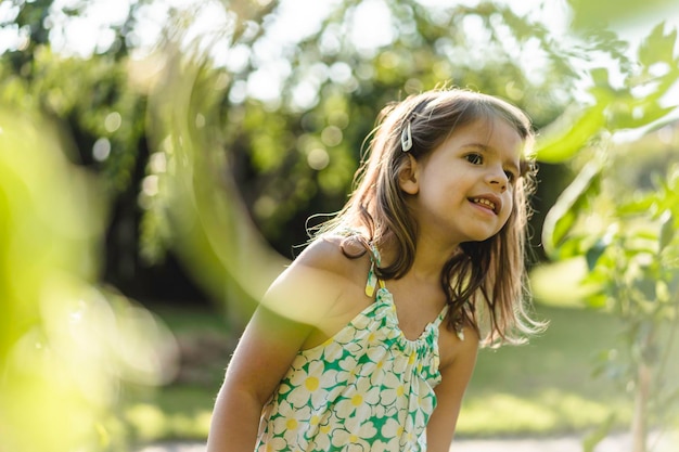 Bambina curiosa in campagna tra piante verdi concetto di sostenibilità dell'infanzia ecologia economia verde ed energia pulita