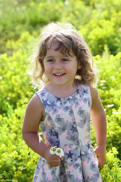 Bambina dentro su un giacimento di fiore