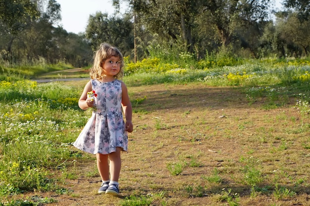 Bambina dentro su un giacimento di fiore