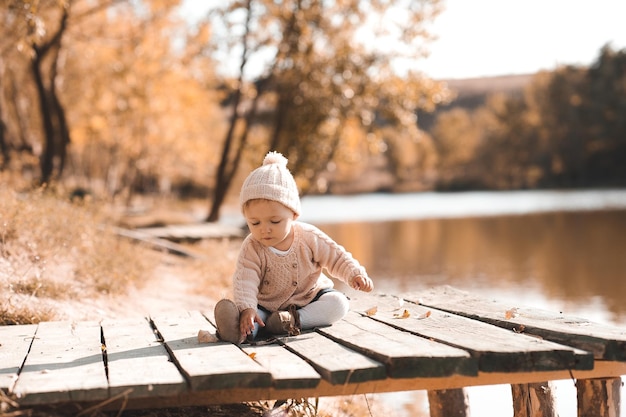 Bambina di 1 anno che gioca nel parco autunnale Indossando abiti alla moda in maglia all'aperto