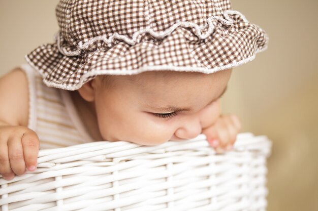 Bambina di otto mesi gioca con il cesto della biancheria