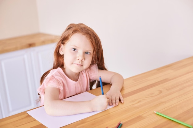 Bambina disegno chiuso blocco esercizio routine fatta in casa lezioni scolastiche scrivere matita su pezzo di carta studio asilo scuola materna elementare donna bambino studente Copyspace