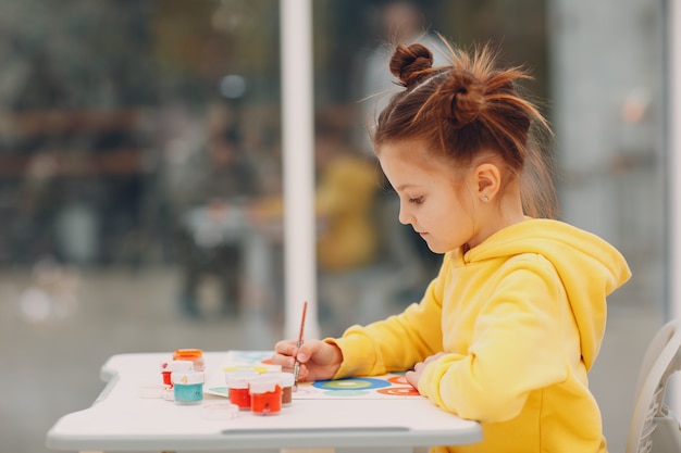 Bambina disegno immagine arte pittura con pennello e colori ad acquerello