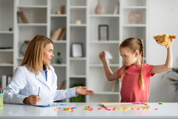 Bambina disobbediente di cattivo umore che fa i capricci all'appuntamento con lo psicologo