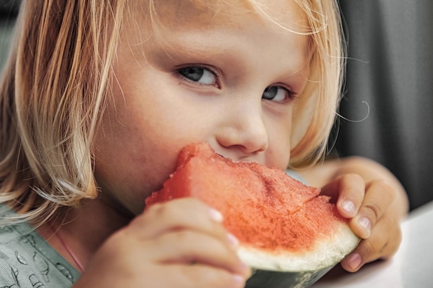 Bambina divertente che mangia il primo piano dell'anguria