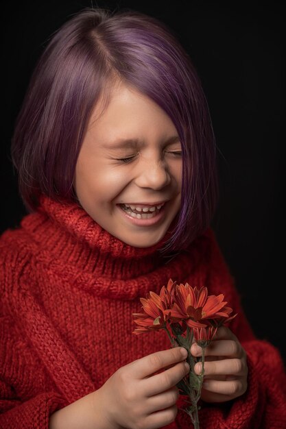 bambina divertente con i capelli viola in un maglione rosso