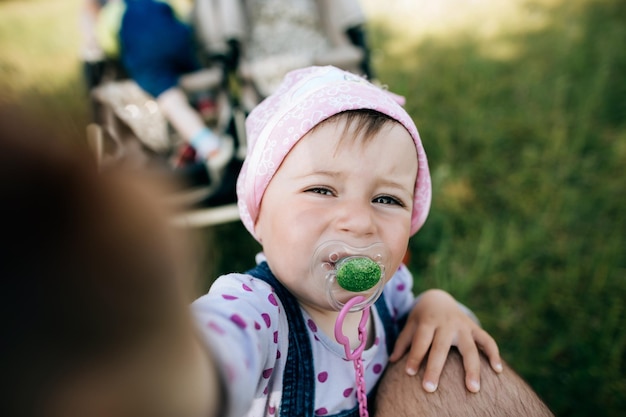 Bambina divertente con un ciuccio in bocca