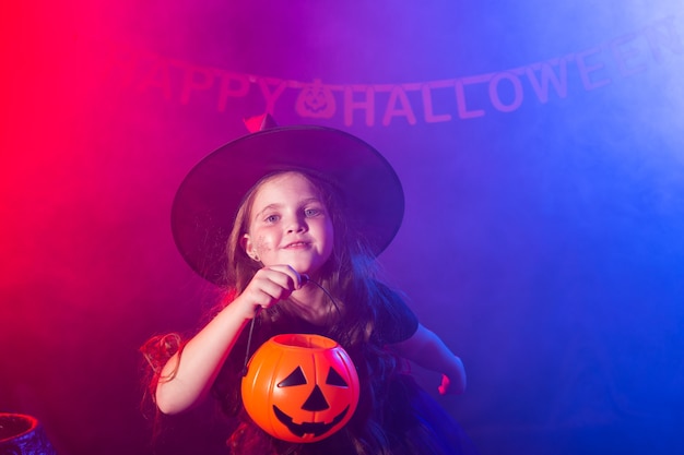 Bambina divertente in costume da strega per halloween con jack zucca