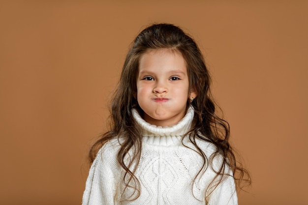 Bambina divertente in maglione bianco che scherza