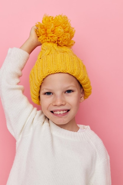 Bambina divertente in un cappello giallo divertente sfondo isolato