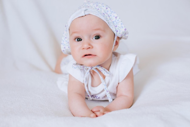 Bambina divertente in un cappello su sfondo bianco