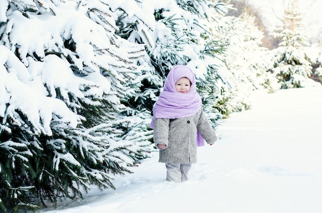 Bambina divertirsi al giorno d'inverno sulla grande neve. Divertimento all'aria aperta per le vacanze di Natale in famiglia. Attività invernali per bambini. Bambino carino che si gode una giornata a giocare nella foresta invernale