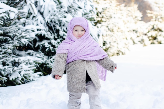 Bambina divertirsi al giorno d'inverno sulla grande neve. Divertimento all'aria aperta per le vacanze di Natale in famiglia. Attività invernali per bambini. Bambino carino che si gode una giornata a giocare nella foresta invernale