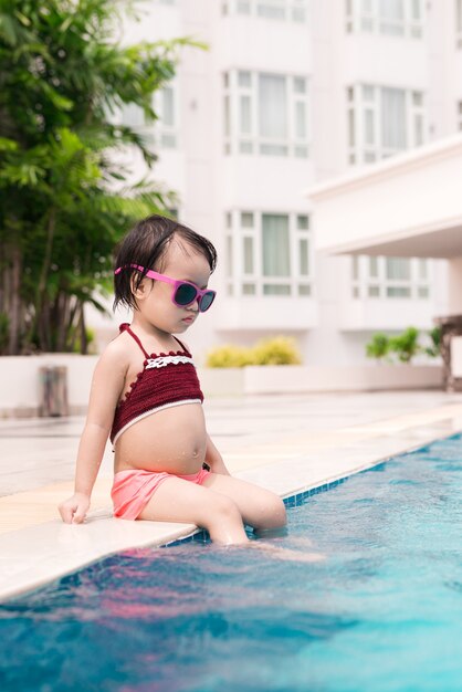 Bambina divertirsi in piscina. Vacanze estive e concetto di vacanza