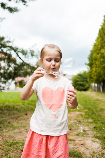 Bambina e bolle di sapone in natura