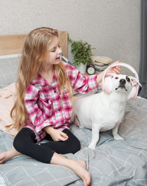 Bambina e cane Bambina mette le cuffie sul suo cane