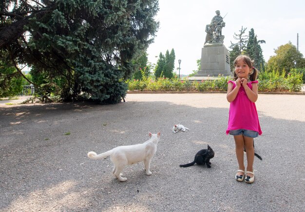 Bambina e gatti in natura